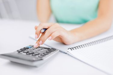 Bookkeeper entering figures into a calculator
