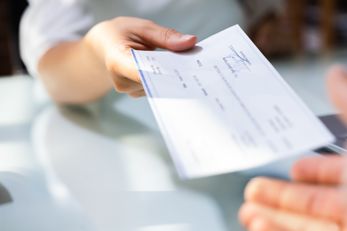 Payslip being handed over a desk