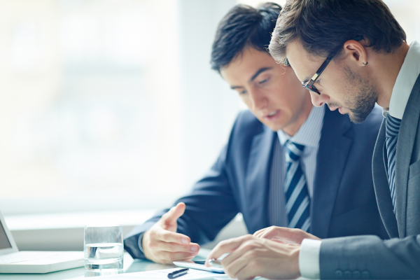 Two business men reviewing their finances from a sheet of paper - Formation of the company