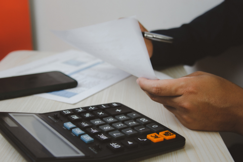 Accountant working with calculator on desk