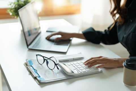 Studying Woman with stationary on the table as well as a laptop